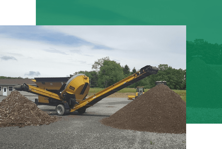 A large pile of dirt is being loaded onto a conveyor belt.