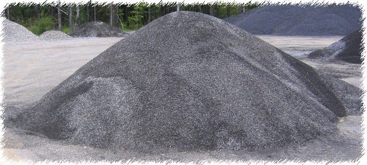 A pile of gravel sitting on top of a cement ground.